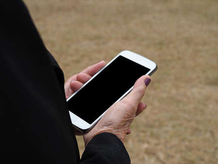 Closeup of old woman hands holding mobile phoneの写真素材