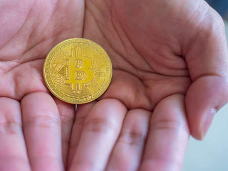 Bitcoin in man's hand closeup cryptocurrency investment concept.の写真素材