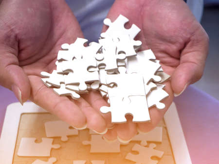 Jigsaw puzzle pieces on palm with sunlight effect.の写真素材