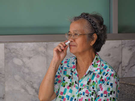 Asian elderly womam with herbal inhalerの写真素材