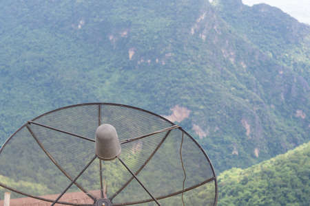 Close-up of black satellite dish with mountain background is located village in the northern at Chiang Rai, Thailand. Technology conceptの写真素材