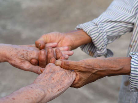 Close-up image of shaking hands between elderly womans. Unity Concept.の写真素材