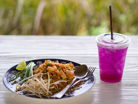 Close-up of padthai (Thai Food) and Herb water on white wooden table.の写真素材