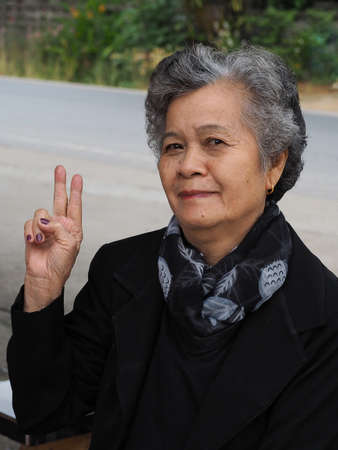Asian elderly woman showing victory signの写真素材