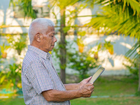 Portrait of senior man holding tablet in his garden.の写真素材