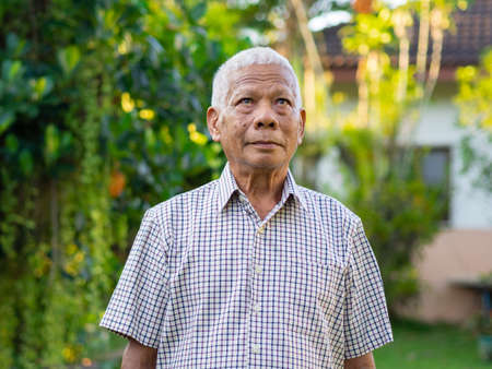 Portrait of senior man looking up in his garden.の写真素材