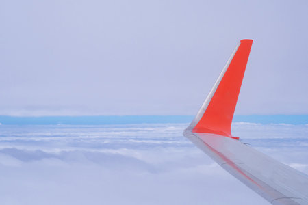 Aerial view of sky seen through airplane window. Bright blue sky and white clouds with skyline background. Space for textの写真素材