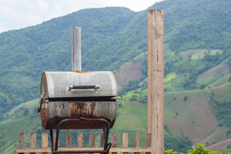 Close-up of old bbq grill stove with mountains background. Space for text.の写真素材