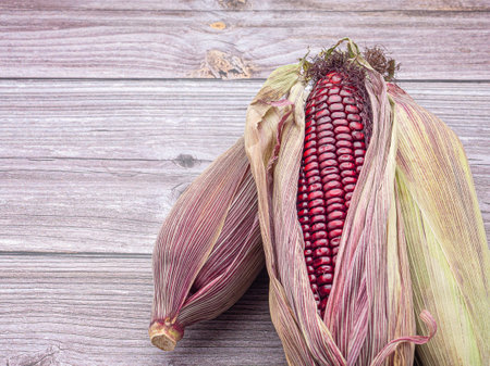 Side view of purple corn or Siam ruby queen isolated on a wooden table. Space for text. Vegan fruit and healthy fruits concept.の写真素材