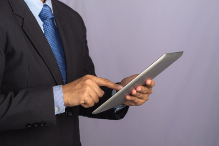 Side view of a businessman using a tablet. Stock market investments funds and digital assets....