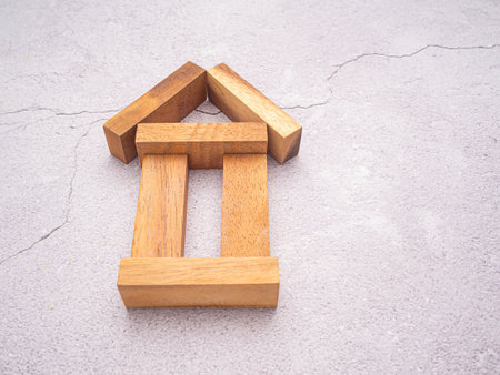 Home loan and real estate investment concept. Small wooden house with image graphic isolated on cement floor background. Top view.の写真素材