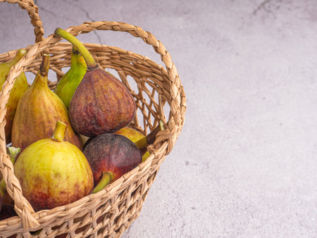Ripe figs fruit in a bamboo basket on a cement floor with space for text. High Vitamins fruit. Concept of fruits healthyの写真素材