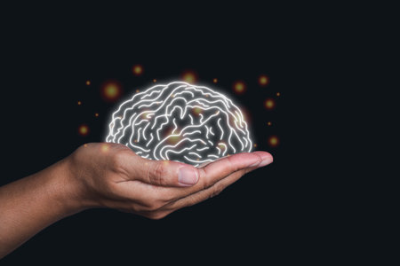 Hand holding a digital image of the brain in the palm on black background. Mental health protection...