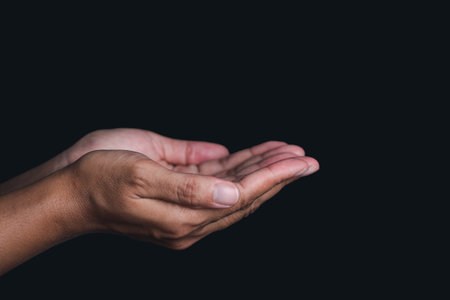 Hands isolated on black background. Hands concept. Outstretched hand. Side view. Dark background.の写真素材