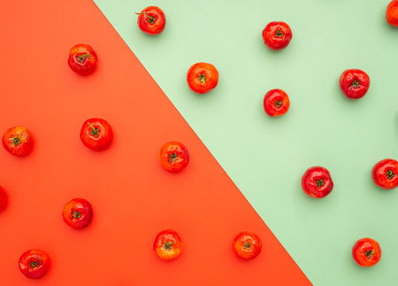 Top view of ripe red acerola cherries fruits isolated on color background. High vitamin C and antioxidant fruits. Top view. Close-up photo. Space for text. Concept of healthy fruits.の写真素材