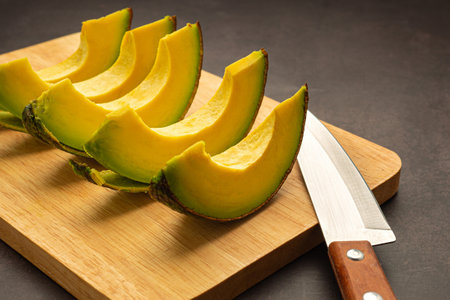 Sliced avocado with a knife on a wooden cutting board. Close-up photo. High vitamin fruit. Healthy fruit concept.の写真素材