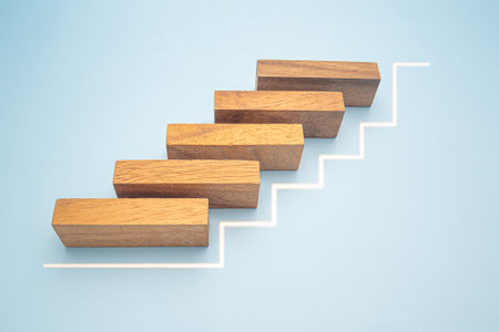 Business growth and investment concept. Wooden blocks stair with white line effect isolated on a blue background for connecting to goal success.の写真素材