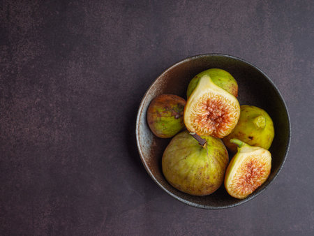 Ripe figs fruit in a bowl placed on the old table in the kitchen. Space for text. High Vitamins fruit. Top view. Close-up photo. Healthy fruits and healthcare concept.の写真素材