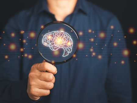 Close-up of a businessman hand holding magnifying glass looking at a digital image of the brain. Artificial Intelligence. AI Technology. Concept of human intelligence with a human brain and thinking.の写真素材