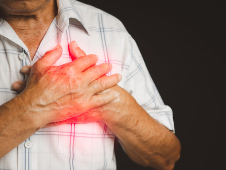 An elderly Asian man in a white shirt has sore left chest pain while standing over a red background...