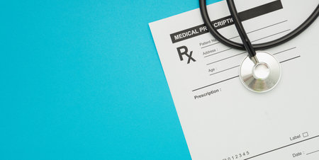 Top view of a stethoscope over on the medical prescription sheet isolated on a blue background. Space for text. Healthcare conceptの写真素材