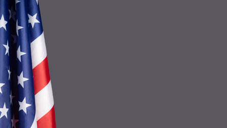 A Close-up of the American flag is on the left side on a gray background with copy space for text. 4th of July. Celebrate American National Day. Labor Day. Independence Day. Memorial Day.の写真素材