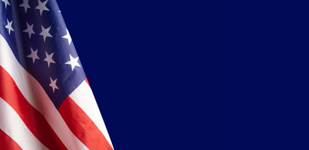 A Close-up of the American flag is on the left side on a blue background with copy space for text....