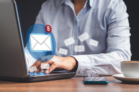 A businessman receives a new message with email icons on a virtual screen. Email notification on the laptop. Email marketing concept. Close-up photoの写真素材