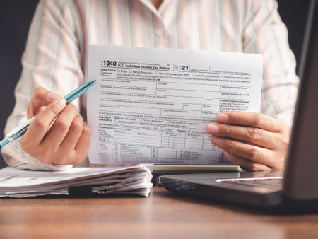 Businesswoman showing a tax form to complete individual income tax payment form. Tax day conceptの写真素材