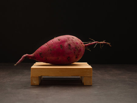 Japanese sweet potato on a wooden with a black background. Close-up photo. Healthy food conceptの写真素材