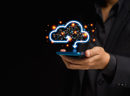 A smartphone connecting to a cloud computing system. Businessman in a suit holding a mobile phone...