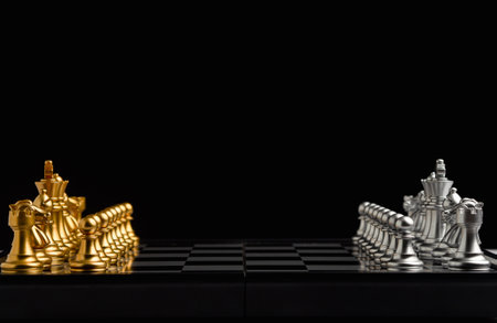 Chess pieces on board game planning and competition on black background. Business leadership and strategy conceptの写真素材