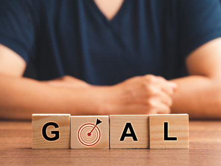 Business and goal concept. Wooden cubes with the letters G, A, L, and target icon on a wooden table. Close-up photo. Business planning, marketing strategy, and investmentの写真素材