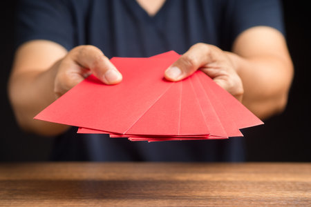 Man in casual holding a red envelope. Close-up photo. Space for text