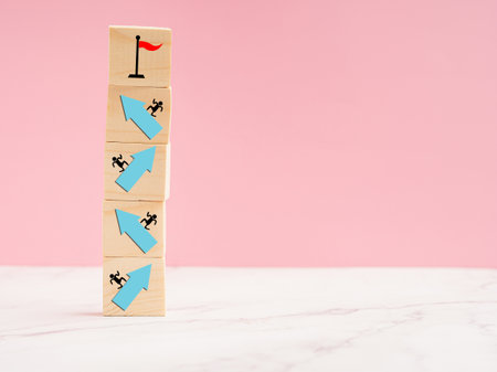 Wooden cubes with blue arrow up a point on a marble floor over a light blue background. Business...