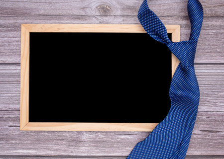 Father's day concept. A blank mini chalkboard and necktie over a wooden table. Space for text. Top viewの写真素材
