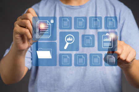 Online documentation database and digital file storage concept. A young man in casual working at digital documents on a virtual screen. Document management system (DMS)の写真素材