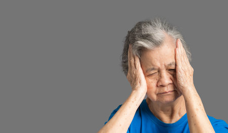 A senior woman who has a severe headache suffers from a stroke, brain attack, or migraines. Brain diseases problem cause chronic severe headaches. Aged people and healthcare conceptの写真素材