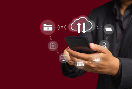 Businessman using a smartphone login to cloud computing on the virtual screen while standing on a...