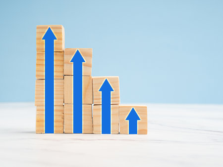 Common goal success concept. Arrows up on wooden cubes with a blue background. Business achieving...