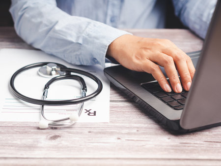 A doctor's using a laptop while sitting in the hospital. Medical consultant concept