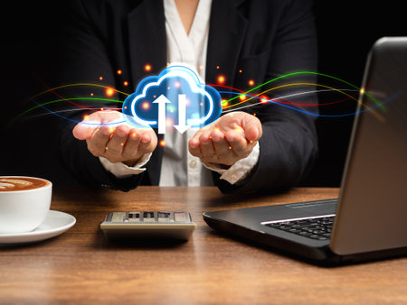 Cloud computing concept. Hand of businesswoman holding virtual cloud computing icon in the palm while sitting in the office. Business, technology, network, and data storage conceptの写真素材