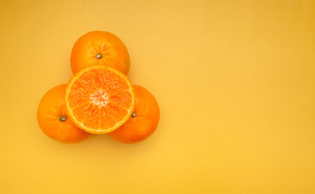 Top view of fresh oranges over a yellow background. Healthy fruit concept. Close-up photo. Space for textの写真素材