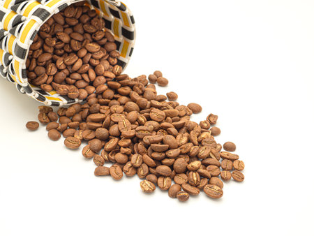 Coffee beans in a colorful basket on white background. Close-up photo. Top viewの写真素材