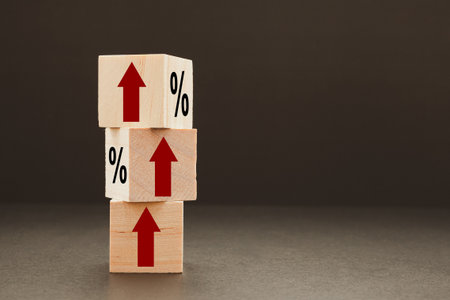 Finance and interest rates concept. Stack of wooden cubes with red arrows up and a black percentage...