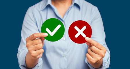 Yes or No. Close-up of hands holding two papers circle shape with a checkmark and cross while...
