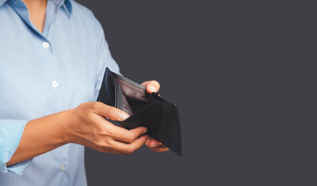 Bankruptcy concept. Close-up of hands man opening an empty wallet while standing on a gray...