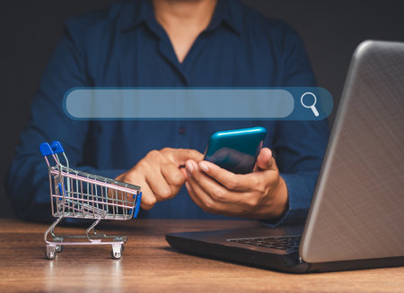 Search engine online concept. Close-up of hands businessman using a smartphone to search for information on a web browser while sitting at the table. Technology and communicationの写真素材