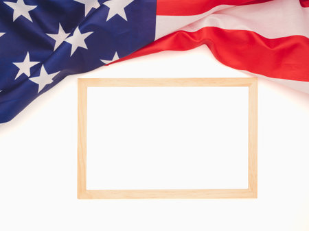 Top view of the American flag and empty mini whiteboard on a white background. Space for text. Close-up photoの写真素材