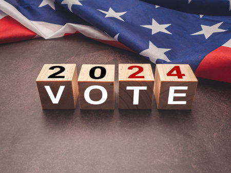 United States presidential election in 2024. Wooden cubes with text VOTE and 2024 over the American flag background. Politics and voting conceptualの写真素材